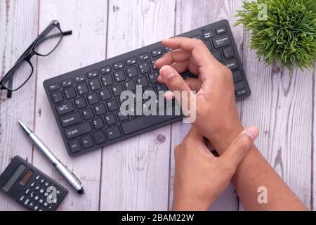 man holding her wrist pain from using computer. Office syndrome Stock Photo