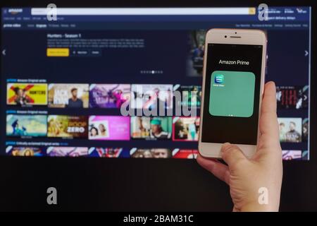 Amazon streaming Service VoD content provider concept. Hand holds before screen mobile phone with Amazon Prime Video online watch application page. Stock Photo