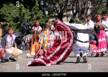 Young Mexican couple Folkloric dancers performing traditional dance, in movement in crouched position Stock Photo