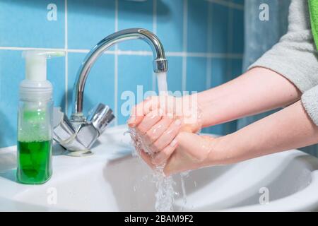 woman washes hands with liquid antibacterial soap, virus prevention Stock Photo