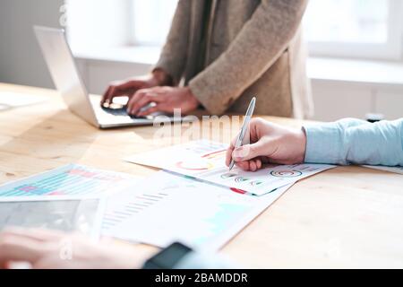 Close-up of unrecognizable financial expert making notes in chart while analyzing month report in office Stock Photo
