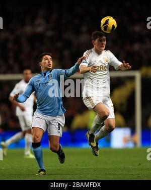 Manchester City's Samir Nasri (left) and Swansea City's Ben Davies battle for the ball Stock Photo