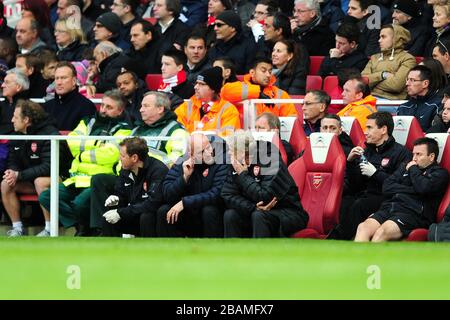 Arsenal manager Arsene Wenger (centre) speaks with his assistant Steve Bould on the bench Stock Photo