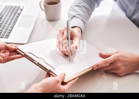 Office administrator giving medical card about his health status to employee for signature in office Stock Photo