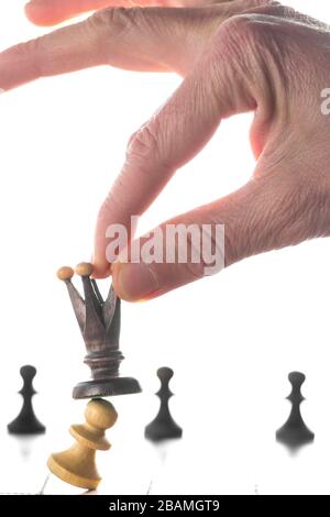 Chess concept with man make move. Hand holding black chess queen on chessboard. Stock Photo