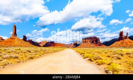 Gravel Road winding through the landscape of Red Sandstone Buttes and Pinnacles in the semi desert landscape in the Valley of the Gods State Park near Stock Photo