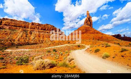 Gravel Road winding through the landscape of Red Sandstone Buttes and Pinnacles in the semi desert landscape in the Valley of the Gods State Park near Stock Photo