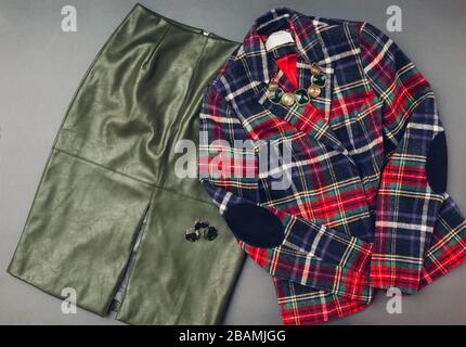 Fashion outfit for woman. Trendy leather green skirt, striped jacket, jewellery. Spring female clothes accessories. Stock Photo