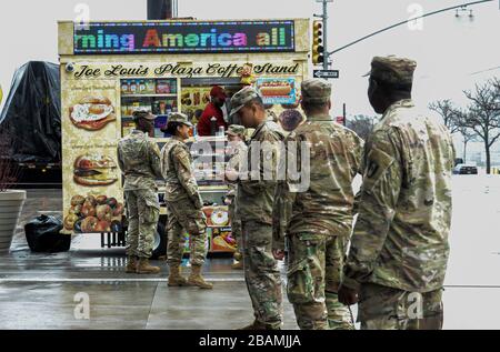 New York Manhattan, USA. 28th Mar, 2020. Army National Guard on the line to buy NYC hot dog out side the The Javits Convention Center. New York Gov. Andrew Cuomo announced the construction of a temporary hospital at the the Jacob K. Javits Center had been completed with the help of FEMA and the National Guard. New York State has over 26,000 cases and 450 people died from the pandemic in NYS in the past 24 hours. 03/28/20. New York Manhattan. Marcus Santos. Credit: Marcus Santos/ZUMA Wire/Alamy Live News Stock Photo