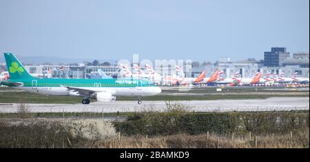 An Aer Lingus Airbus A320-214 moves towards take off at Gatwick Airport passing in front of many grounded British Airways and easyJet planes. Stock Photo