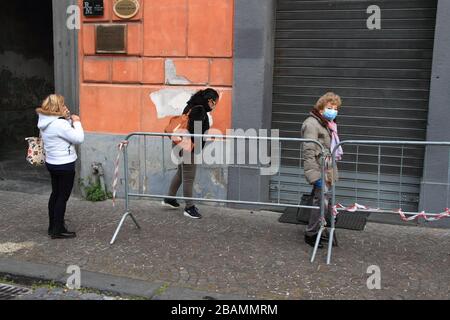 Pagani,Sa,Italy - March 28,2020 :Persons queuing outside the Italian Post Office to be able to pick up their pension or pay bills respecting the secur Stock Photo