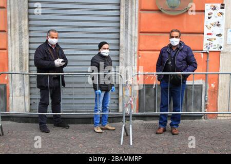 Pagani,Sa,Italy - March 28,2020 :Persons queuing outside the Italian Post Office to be able to pick up their pension or pay bills respecting the secur Stock Photo