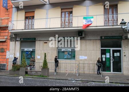 Pagani,Sa,Italy - March 28,2020 :Persons queuing outside the Italian Post Office to be able to pick up their pension or pay bills respecting the secur Stock Photo