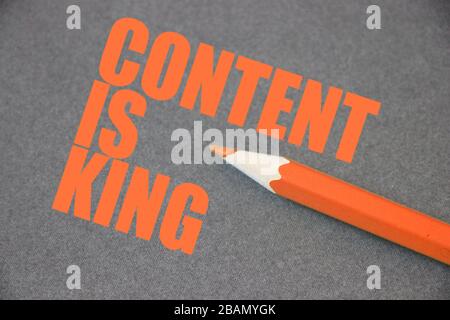 Content is king written on blackboard with orange crayon pencil. Search Engine Optimization concept Stock Photo