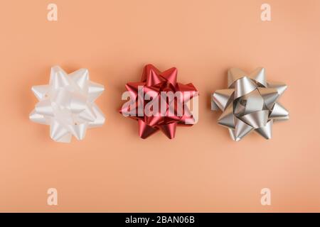 Colorful gift wrapping bows and silver sequins on white festive