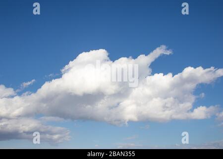 White fluffy clouds on bright blue sky Stock Photo