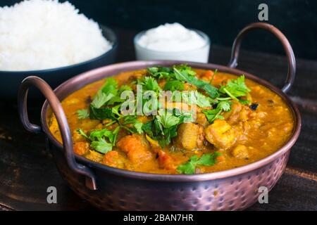 Curried Roasted Eggplant with Smoked Cardamom and Coconut Milk: Eggplant curry topped with mint and cilantro shown with basmati rice and yogurt in the Stock Photo