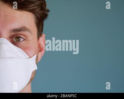 Closeup of a caucasian man face wearing funny monkey face protection mask with a brown eyes and hair, since new coronavirus outbreak. Stock Photo