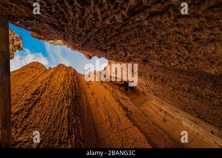 The dark and light brown walls of the clay hoodoos of Cathedral Gorge State Park host a beautiful blue sky Stock Photo