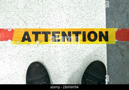 Montreal, Canada - March 28, 2020: Attention line on floor in store to keep social distancing. Social distancing is deliberately increasing the physic Stock Photo