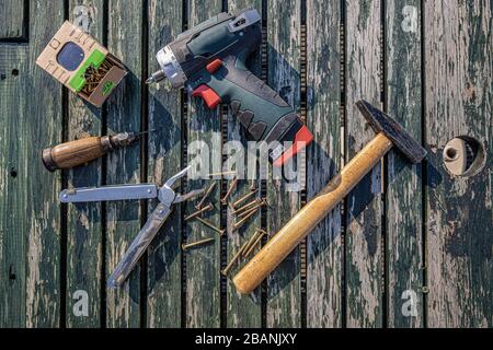 Tool and screw on a wooden plate Stock Photo