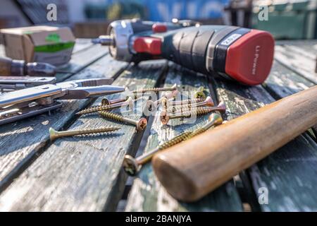 Tool and screw on a wooden plate with perspective blurs Stock Photo