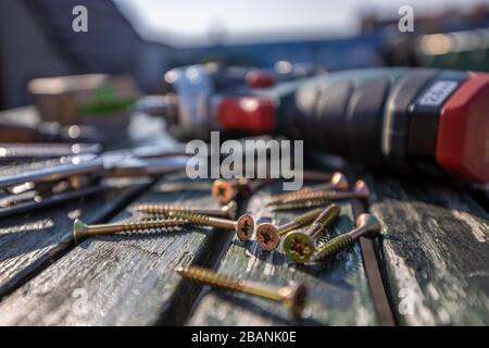 Tool and screw on a wooden plate with perspective blurs Stock Photo