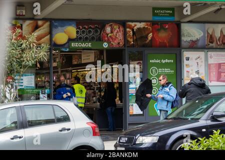 People waiting to enter to the AB Vasilopoulos supermarket outside keeping safe distance. Athens, Greece. Stock Photo