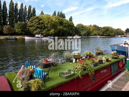 Numerous live-aboard houseboats line the Thames River quay, Kingston Upon Thames, England.  The 'Whirligig' is one of the more fanciful. Stock Photo