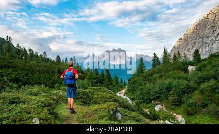 Hikers on a hiking trail, hiking trail to Lago di Sorapis, in the back mountain group Cadin peaks, Cima Cadin, Dolomites, Belluno, Italy Stock Photo