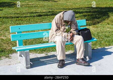 Miami Beach Florida,Lummus Park,man men male adult adults,Black bench,homeless,vagrant,dozing,sleeping,FL110131034 Stock Photo