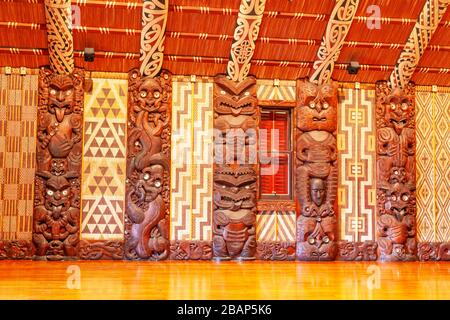 Traditional Maori carvings in the interior of Te Whare Runanga, the Maori Meeting House, in Waitangi, North Island, New Zealand. Stock Photo