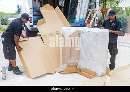 Miami Beach Florida,Macy's,driver,delivery,delivering,deliveryman,furniture,mover,recliner chair,Asian Asians ethnic immigrant immigrants minority,Bla Stock Photo
