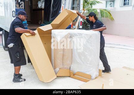 Miami Beach Florida,Macy's,driver,delivery,delivering,deliveryman,furniture,mover,recliner chair,Asian Black African Africans,man men male adult adult Stock Photo