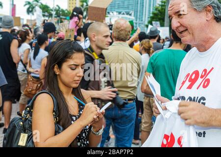 Miami Florida,Occupy Miami demonstration,protest protesters journalist reporter,taking notes writing interviewing woman female man male media Stock Photo