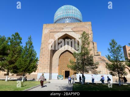 Courtyard view of Bibi-Khanym Mosque lateral building. Persian with blue ceramic tiles and turquoise dome. Bibi Khanum in Samarkand, Uzbekistan. Stock Photo