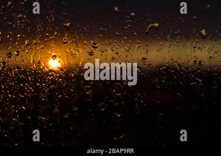 The sun in the rain. Raindrops on glass and sunset Stock Photo