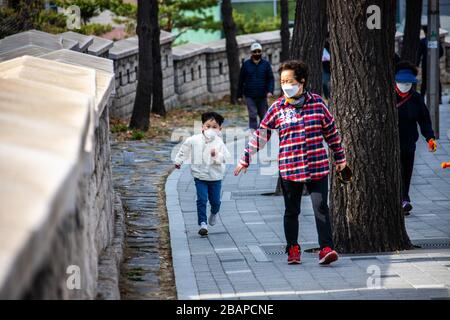 Young boy and his grandmother wearing protective masks during the Coronavirus pandemic, Seoul, South Korea Stock Photo