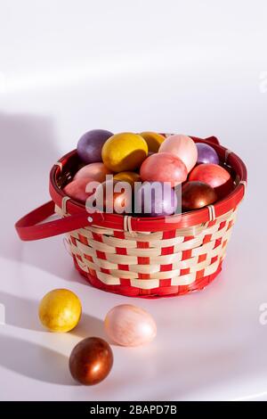 Easter painted eggs in basket isolated on white Stock Photo