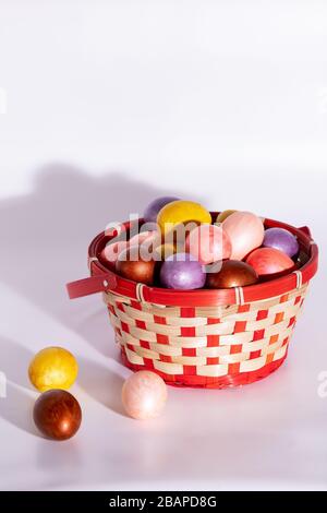 Easter painted eggs in basket isolated on white Stock Photo
