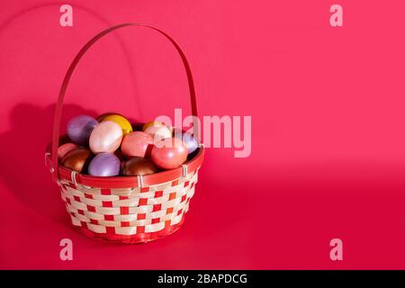Easter painted eggs in basket isolated on red Stock Photo