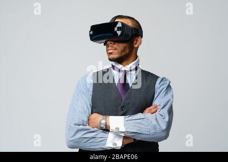 African businessman wearing virtual goggles with hands up isolated on ...