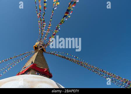 Boudha Stupa, at Kathmandu city in Nepal against blue sky, with religious colorful flags waving. Stock Photo