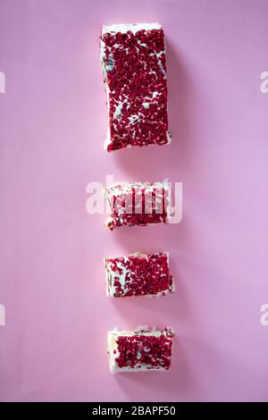 Torrone or nougat bar with nuts and red dried berries. Traditional italian dessert close up on pink background. Sweet tasty and healthy food Stock Photo