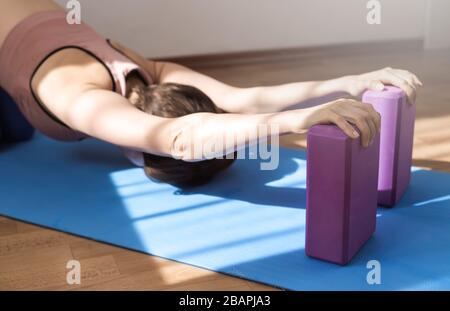 A woman practices yoga at home. Asana for a healthy body. Stock Photo