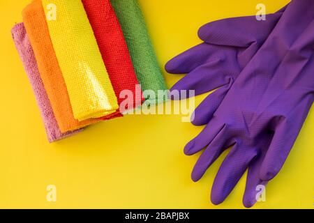 House cleaning products on yellow table. cleaning supplies.Rubber protective gloves and colorful microfiber cleaning cloths .Copy space Stock Photo