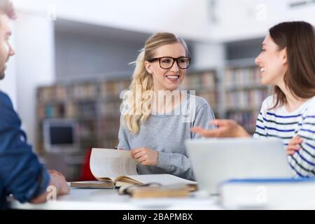 University students working in the library at campus Stock Photo