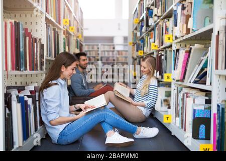 University students working in the library at campus Stock Photo