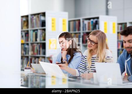University students working in the library at campus Stock Photo