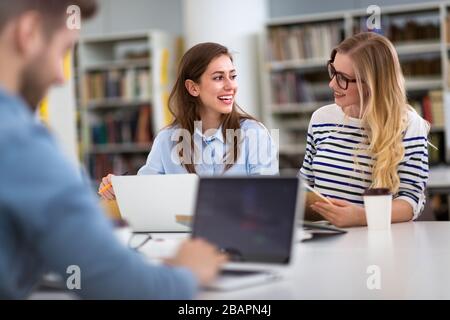 University students working in the library at campus Stock Photo